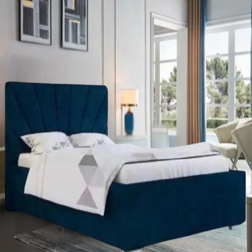 A modern bedroom with a dark blue Arlo Sunshine bed, white duvet, blue lamps, abstract artwork, and a large window with beige and blue curtains.