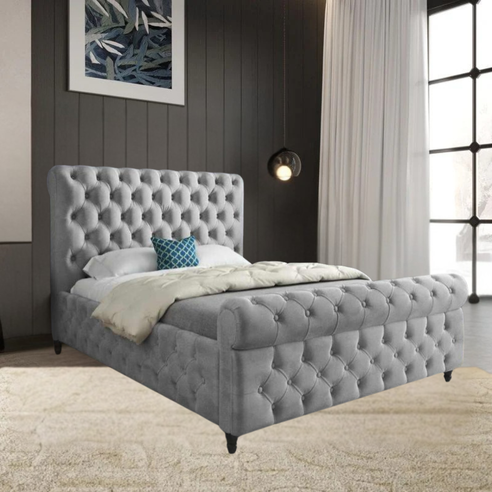 Bedroom with grey tufted Swan Sleigh bed, white bedding, and blue accent pillow, featuring dark walls, sheer curtains, pendant light, and abstract wall art.