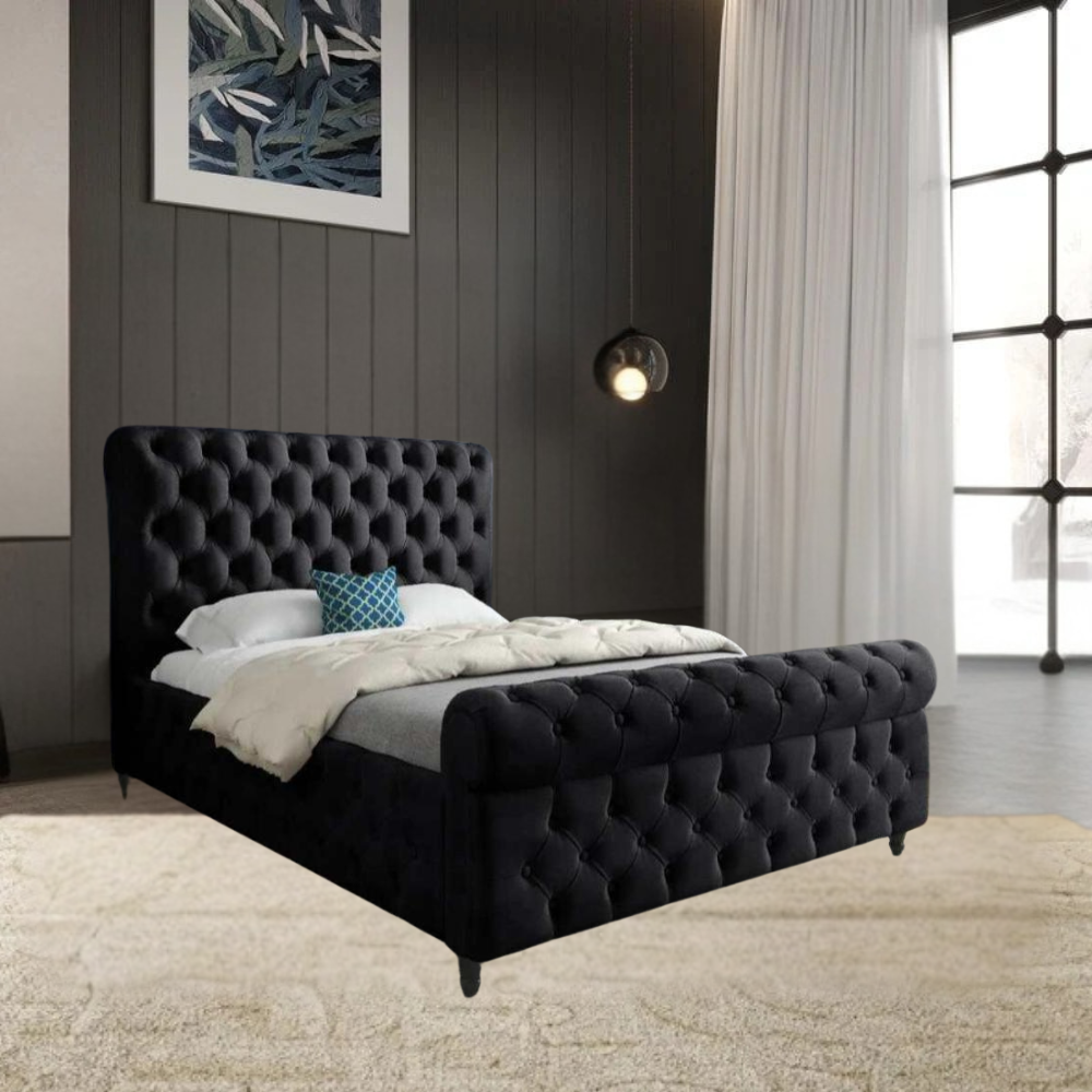 A bedroom with a dark gray tufted SwanSleigh bed, white bedding, and a blue accent pillow, featuring dark paneled walls and a large window with sheer curtains.