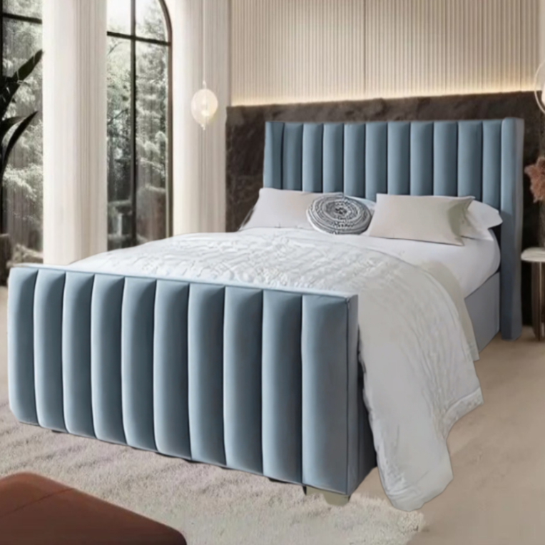A modern bedroom with a blue tufted Erik Panel Bed, white bedding, and stylish decor in a warm, inviting setting.