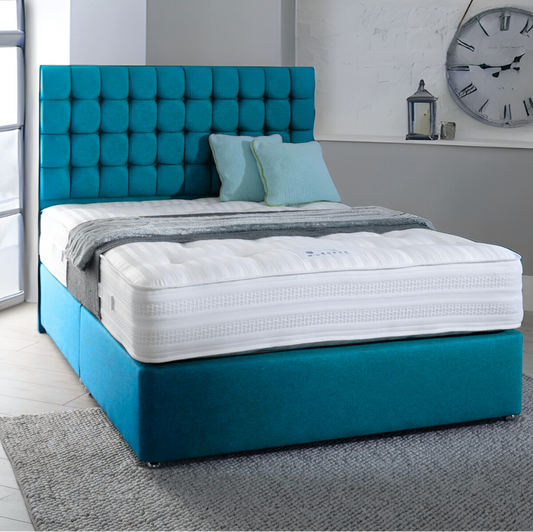 A MarioCubeBed with a teal tufted headboard, white mattress, and light blue cushions.

