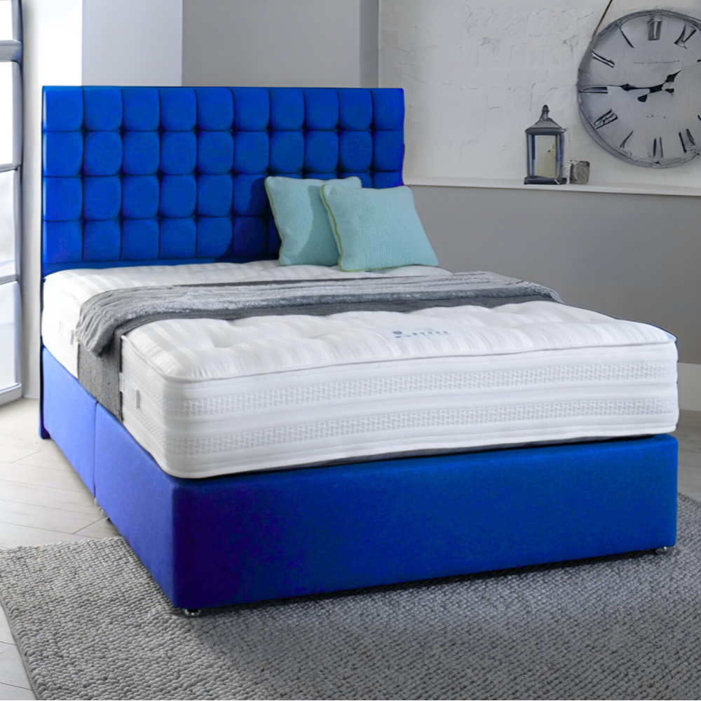 Bedroom with a blue upholstered MarioCubeBed, a white mattress, teal pillows, and a wall clock.

