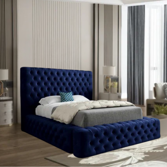 Bedroom with a dark blue tufted MillyAmbassador bed, white bedding, and modern furnishings.

