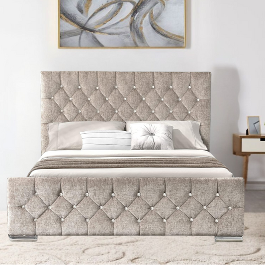 A beige upholstered StellaFlorida bed with a diamond tufted headboard and an abstract painting above it in a stylish bedroom setting.