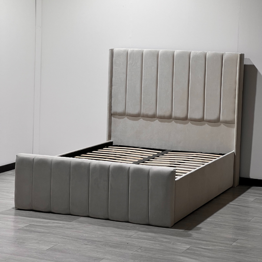 A modern TysonPaneledWingbackBed  frame with a light-gray upholstered headboard and footboard featuring vertical channel tufting.

